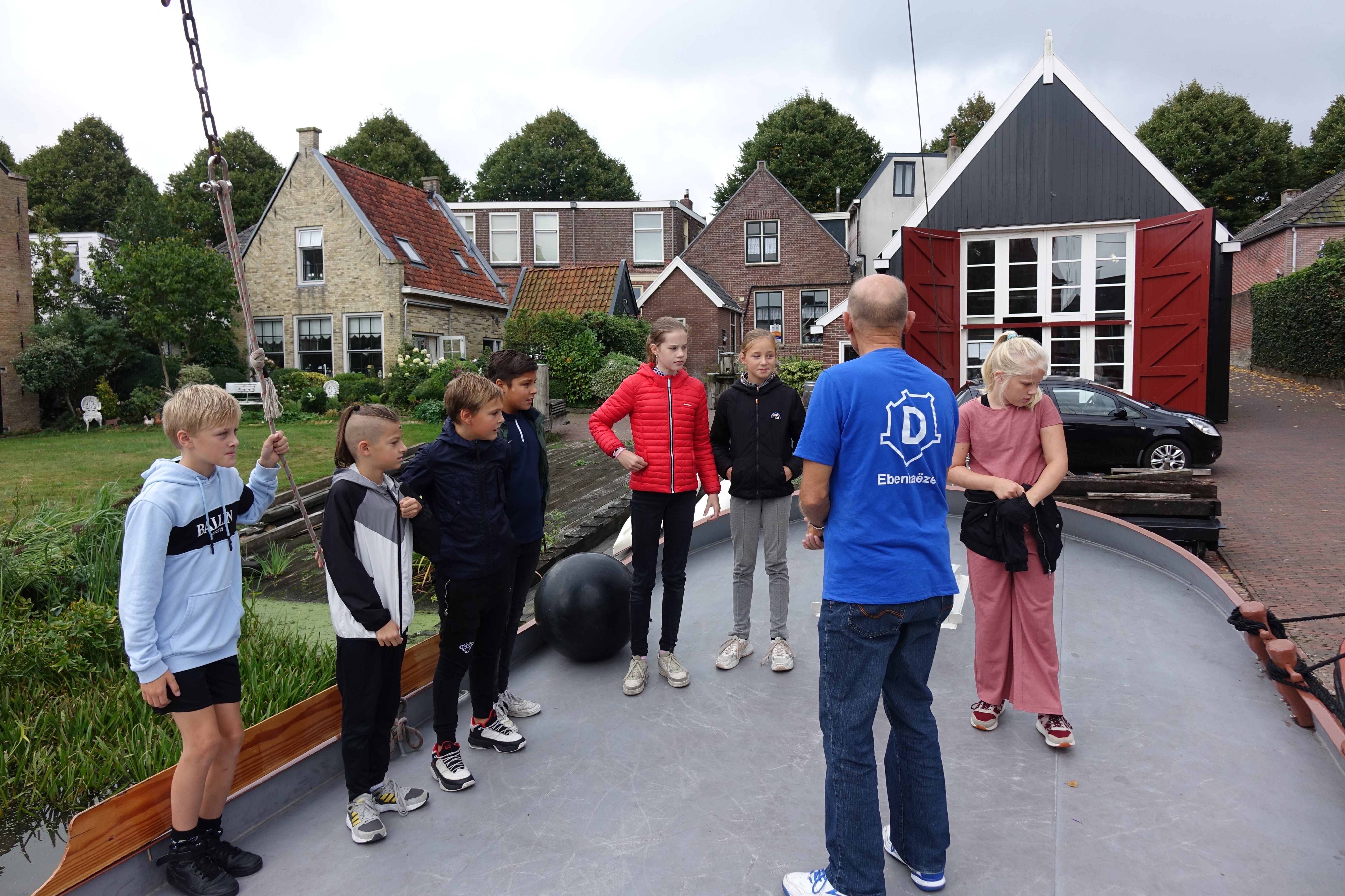 Kinderen op het dek van de Ebenhaëzer, geleid door een bemanningslid
