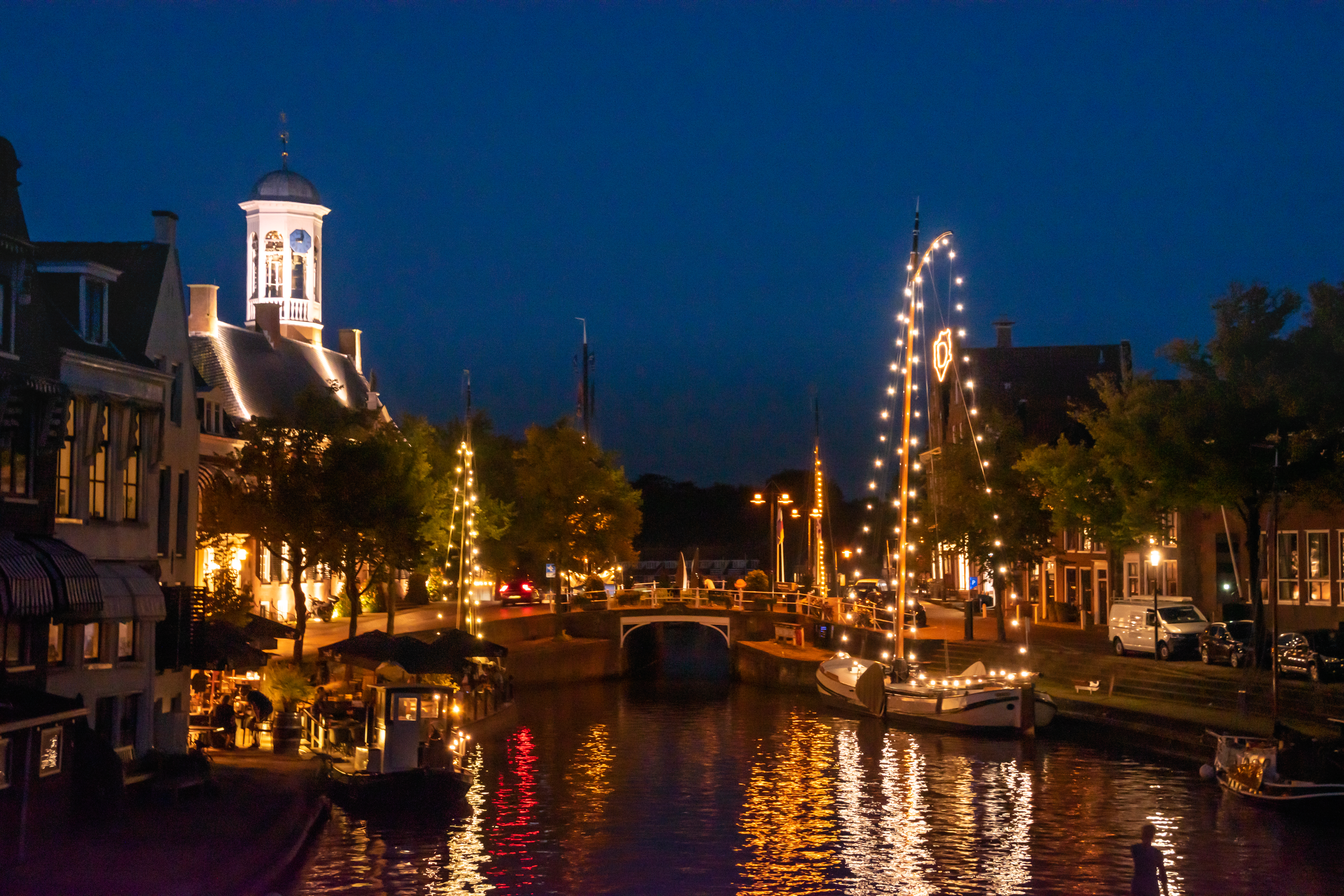 Skûtsje Ebenhaëzer verlicht in de Dokkumer binnenstad bij avond